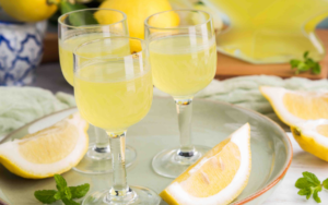 3 verres de limoncello et tranches de citron dans un plateau